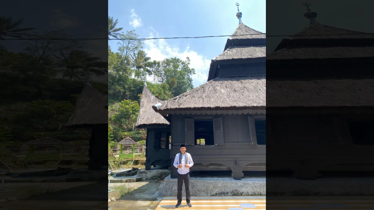 Kadis Parbud Marcos Sophan dengan latar belakang Masjid Tuo Kayu Jao